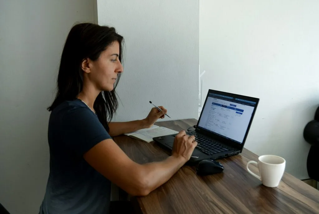 A flat, friendly image showing a business owner sitting at a desk planning website content